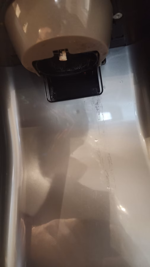 Inside the Samsung refrigerator dispenser cavity showing the actuator bracket where the plastic paddle snapped off.
